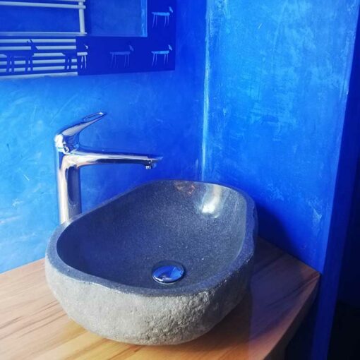 Kamienna umywalka i niebieska łazienka